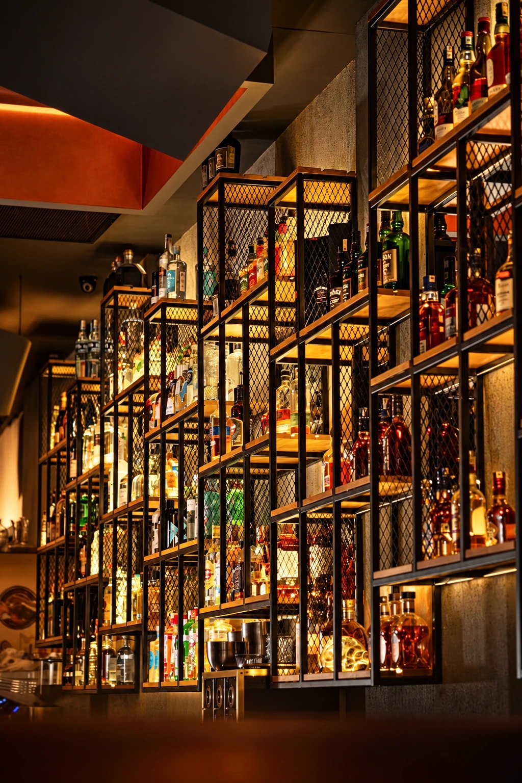 Warmly lit shelves with a broad selection of spirits at Barrel Bar Alanya